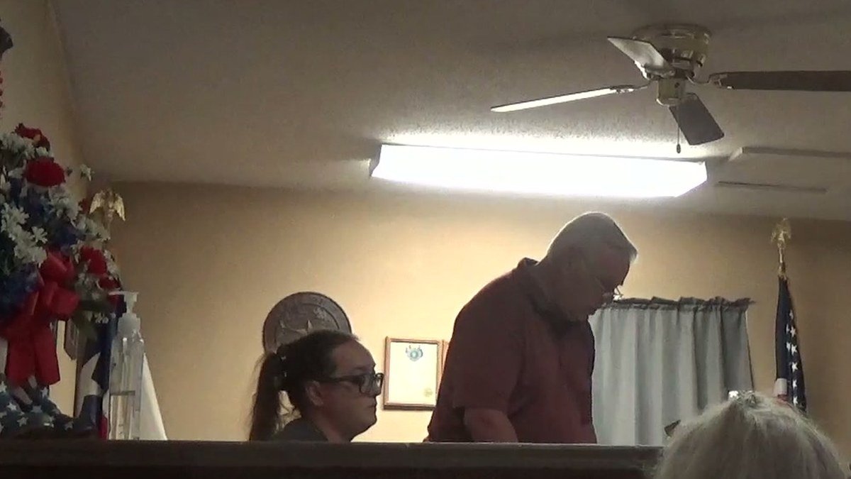 Frame from the September 9, 2023 special session video: a man standing at the Council dais reading, a woman seated beside him